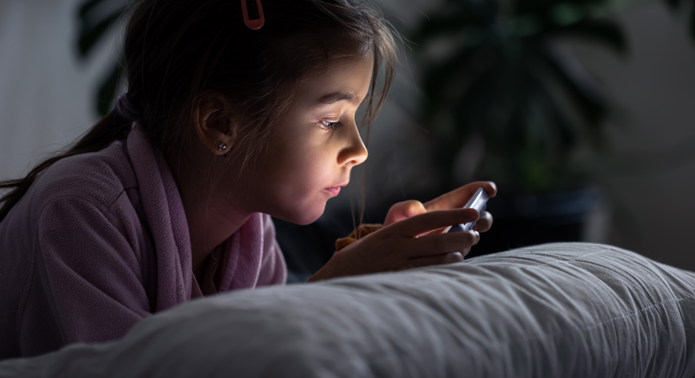 Child using a mobile phone before bedtime